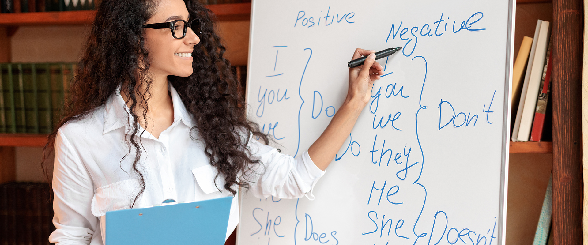 Profesora señalando ejercicios de inglés en pizarra