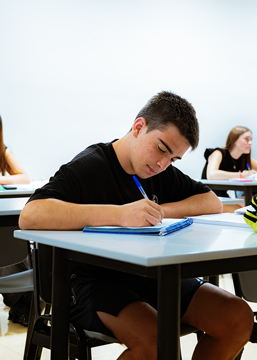 Estudiante de 2º ESO hasta 1º Bachillerato escribiendo en un cuaderno.