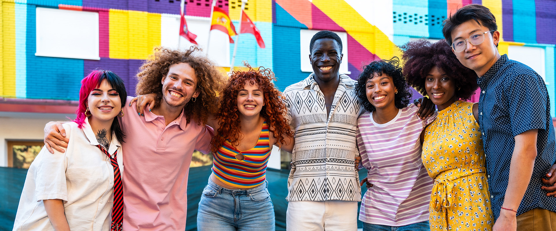 Grupo diverso de jóvenes sonriendo al aire libre.