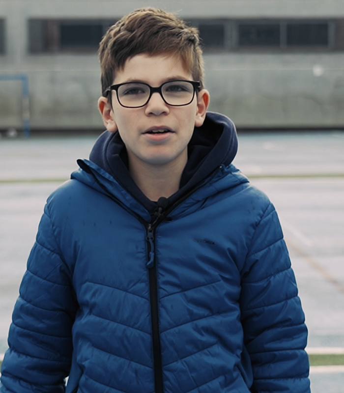 Retrato de chico joven con abrigo azul mirando a cámara. Jorge Lostal, alumno de Colegio de Navidad Piquer
