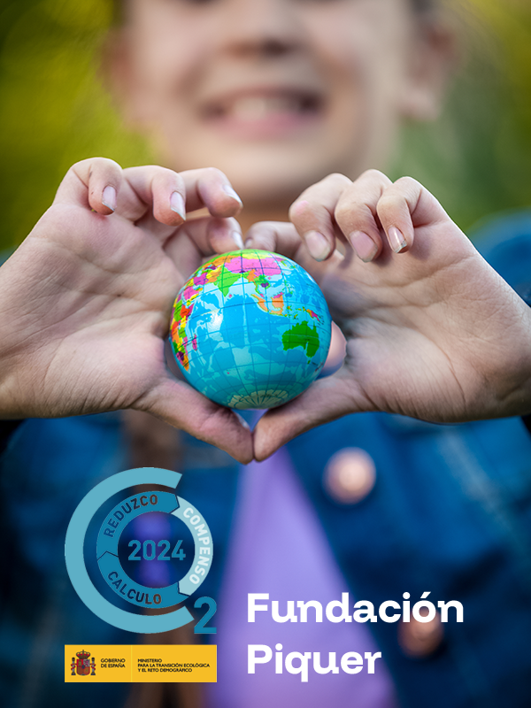 Manos sujetando un pequeño globo terráqueo.